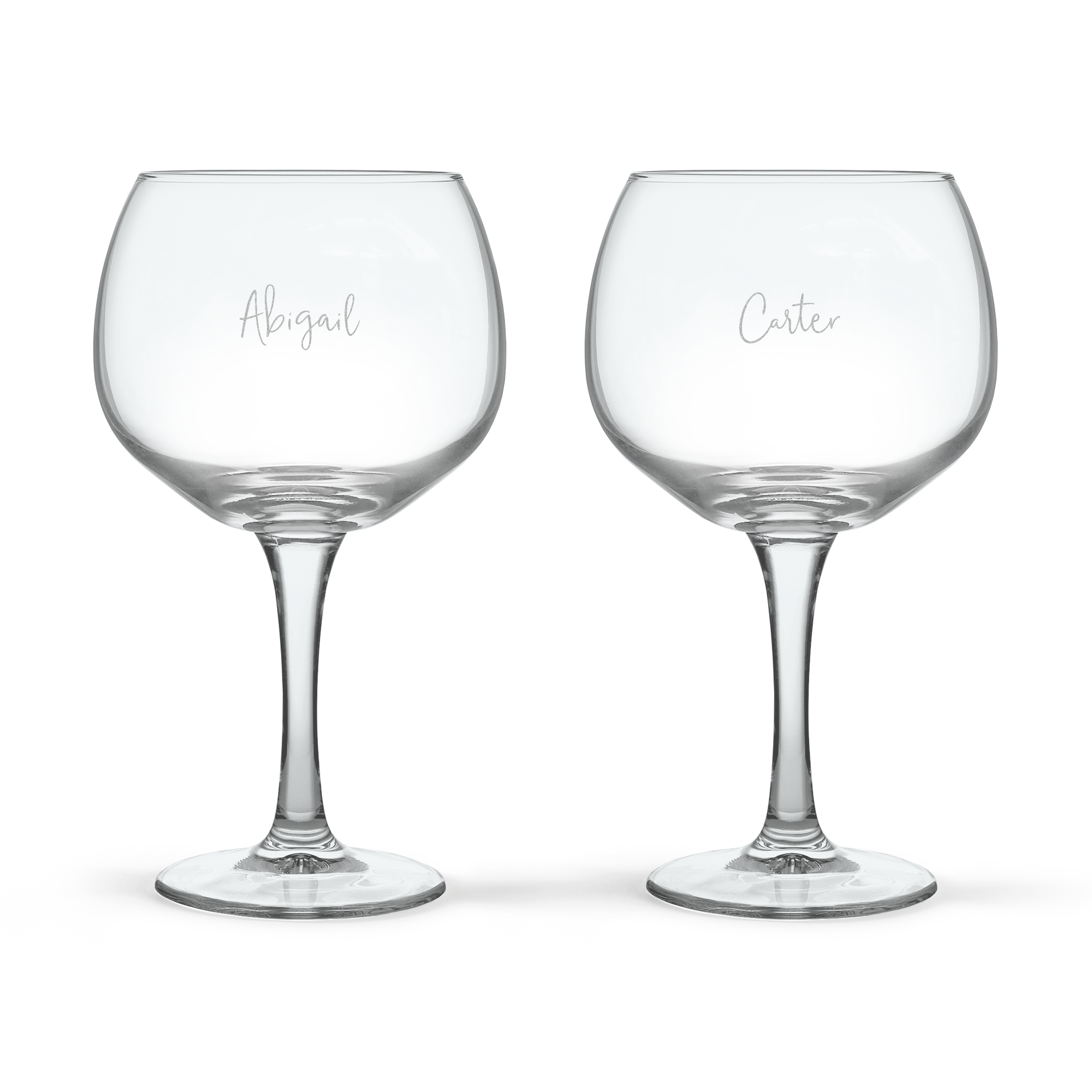 Two personalised Gin Tonic glasses, one engraved with Abigail and the other with Carter, showcasing custom text.