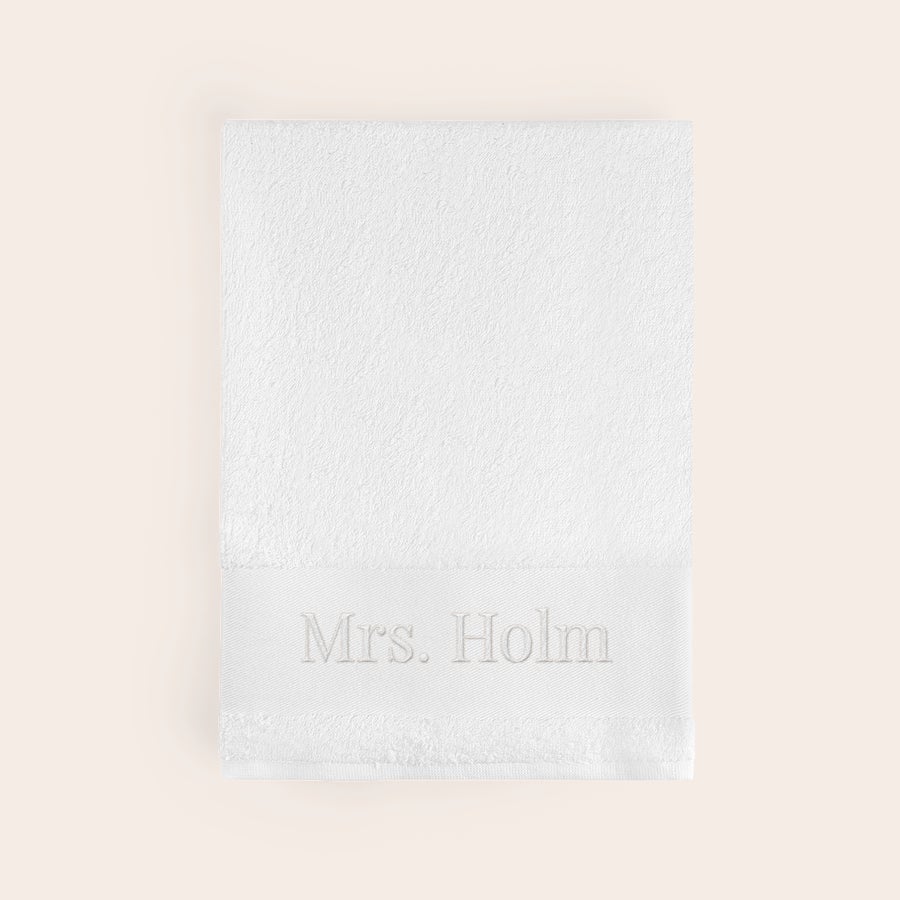 Håndklæde med tekst Blødt hvidt håndklæde broderet med navnet Mrs. Holm, et superblødt og sjusket håndklæde