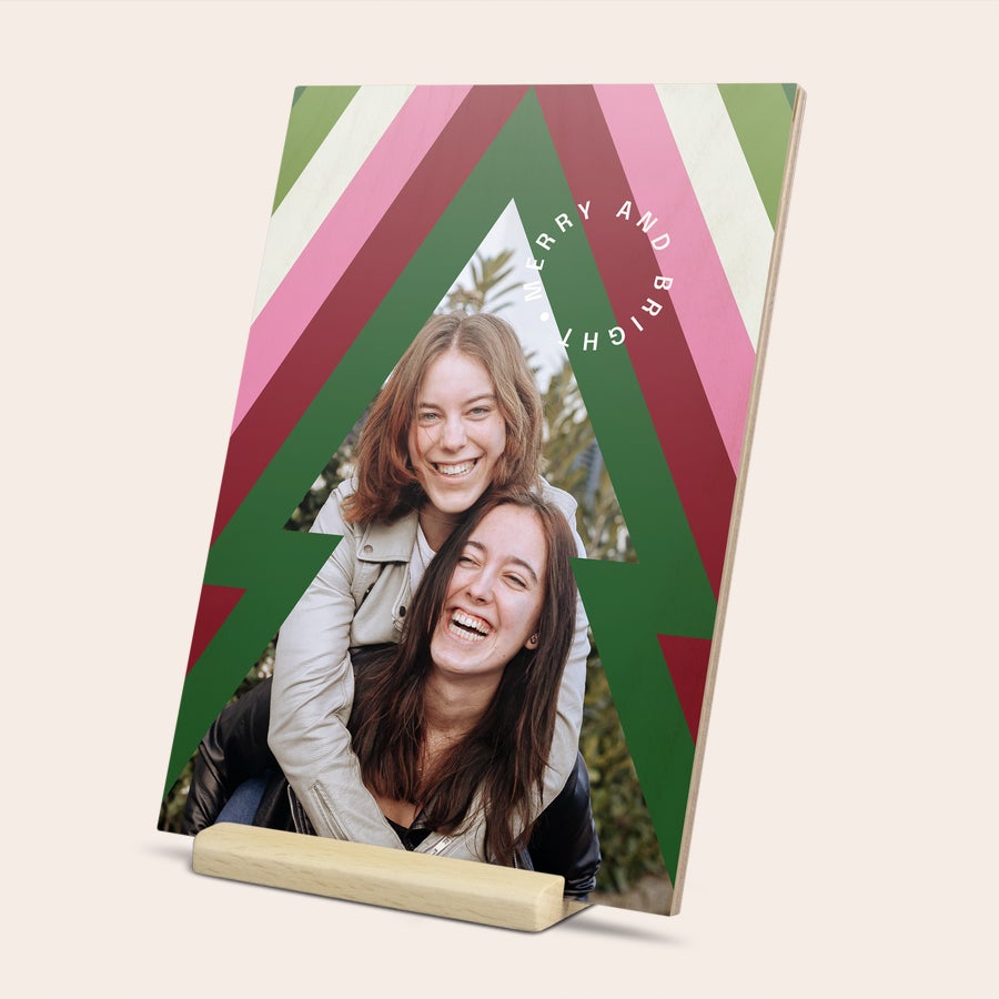 Tarjeta de Navidad con foto Una tarjeta de madera para enviar tu mensaje de Navidad, impresa con una foto de dos chicas sonriendo y un diseño de árbol de Navidad con texto "Merry and Bright".