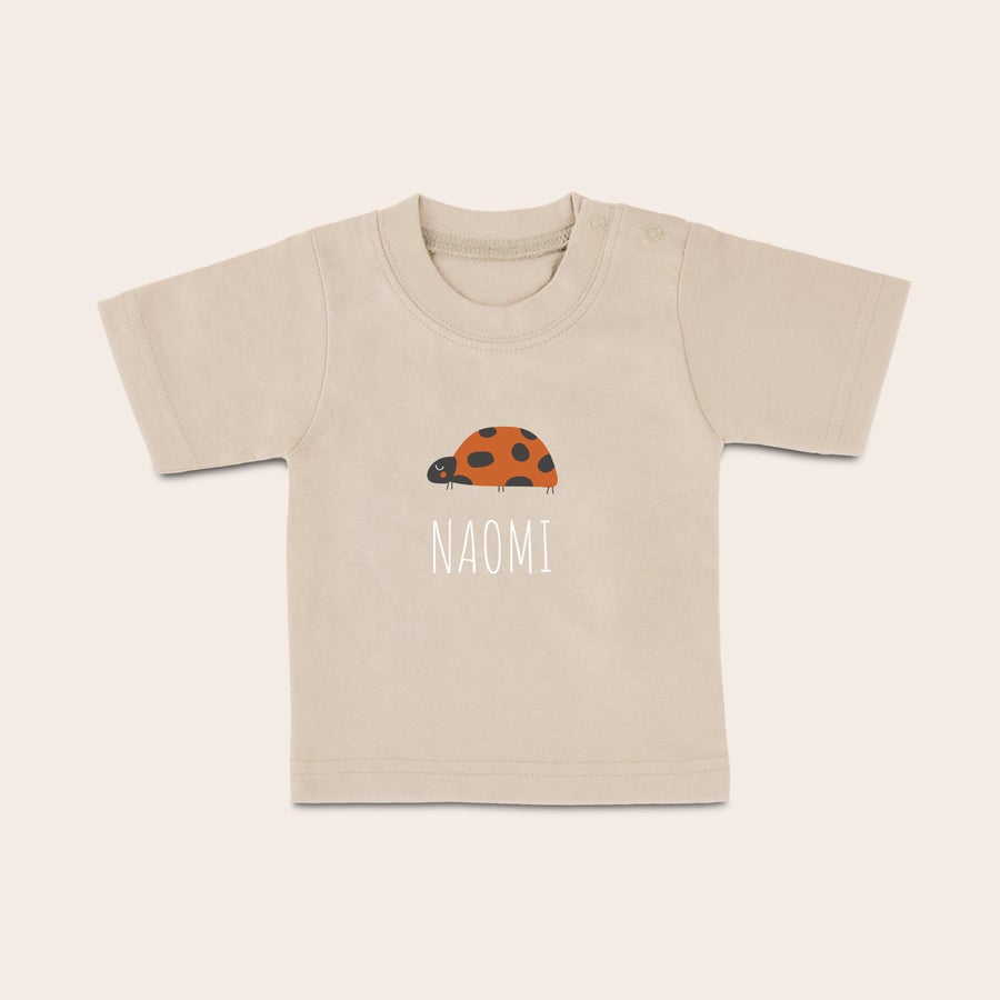 T shirt bébé personnalisé T-shirt bébé beige personnalisé imprimé avec une coccinelle et le prénom Naomi pour un look stylé