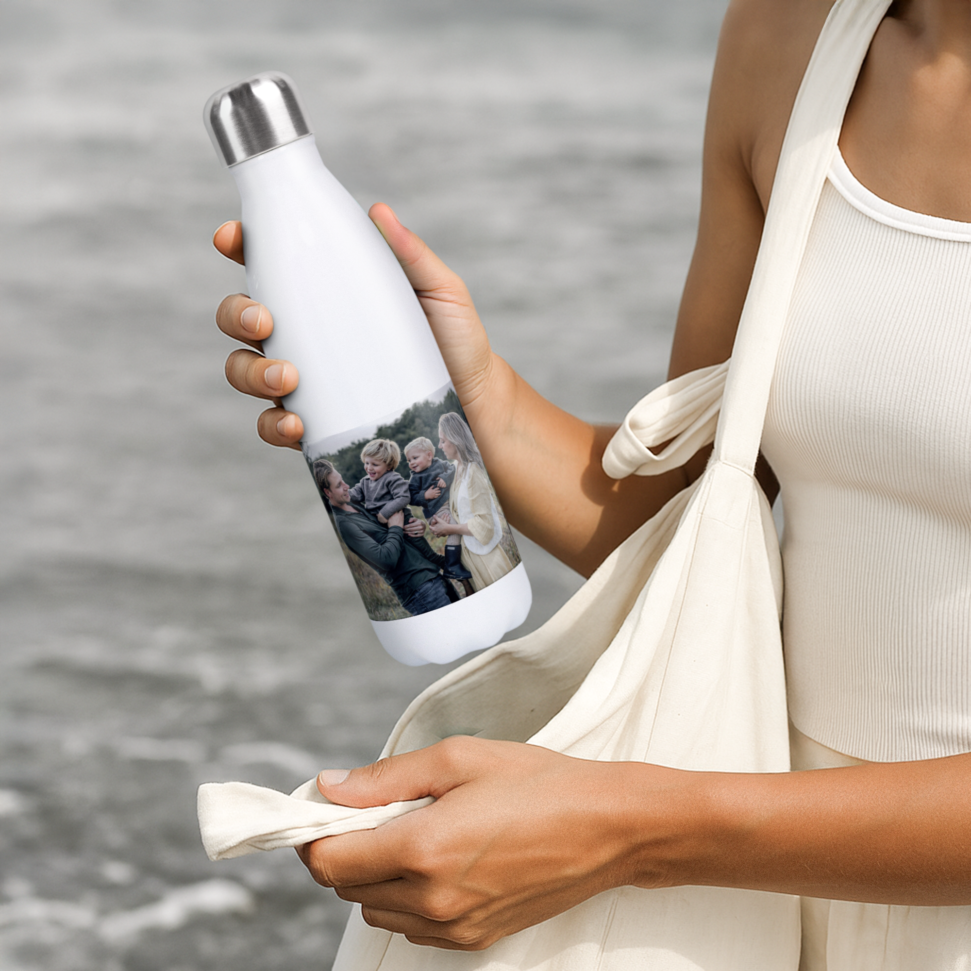 A person holding a personalized insulated water bottle with a printed family photo