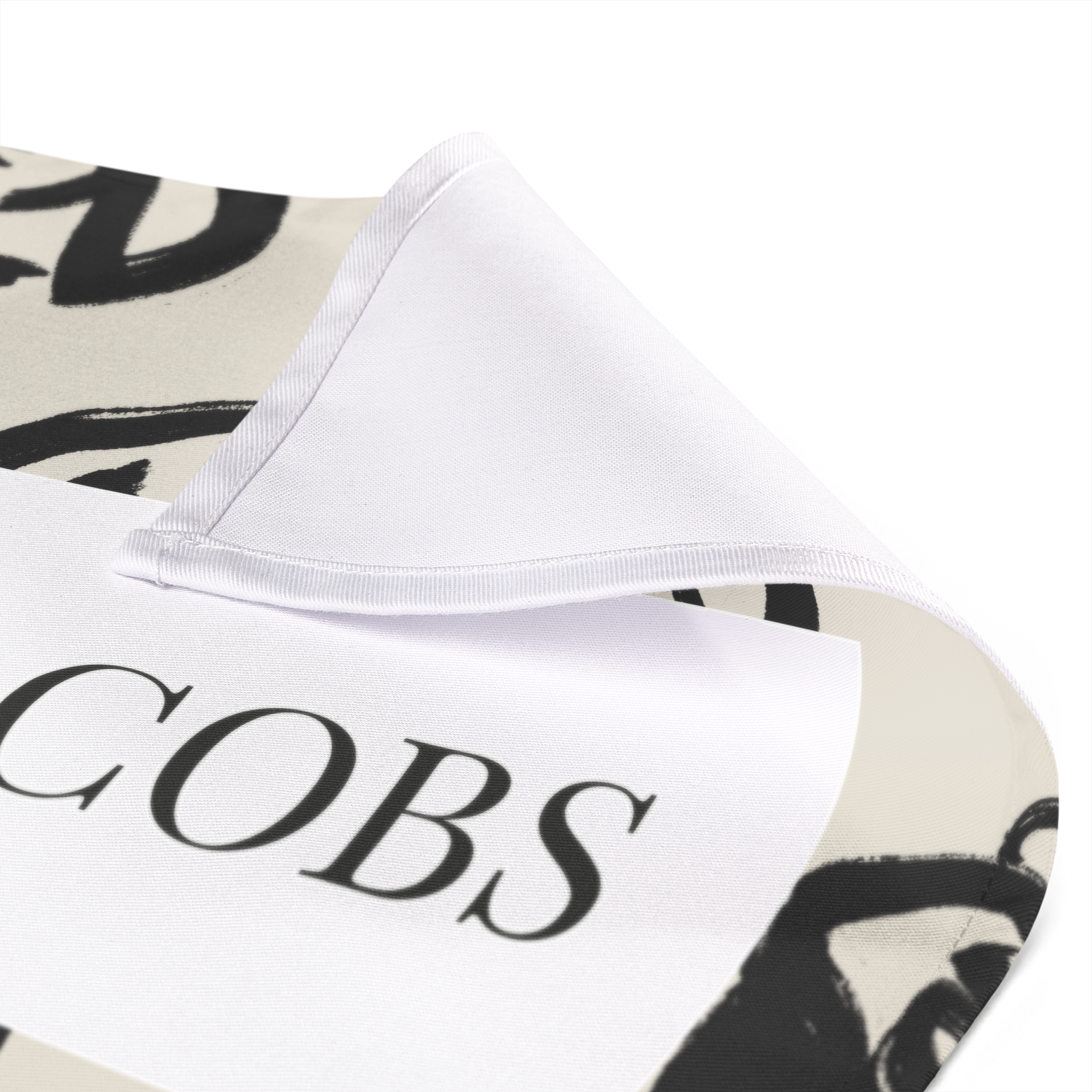 Wit bedrukt servet met zwarte letters 'COBS' en een abstract patroon, deels omgevouwen. Het dekken van de tafel wordt een feestje met unieke bedrukte servetten.