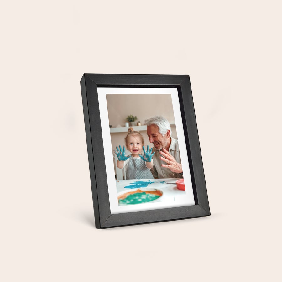 Personalised photo print with frame Personalized photo print in a black frame showing a child and adult with painted hands