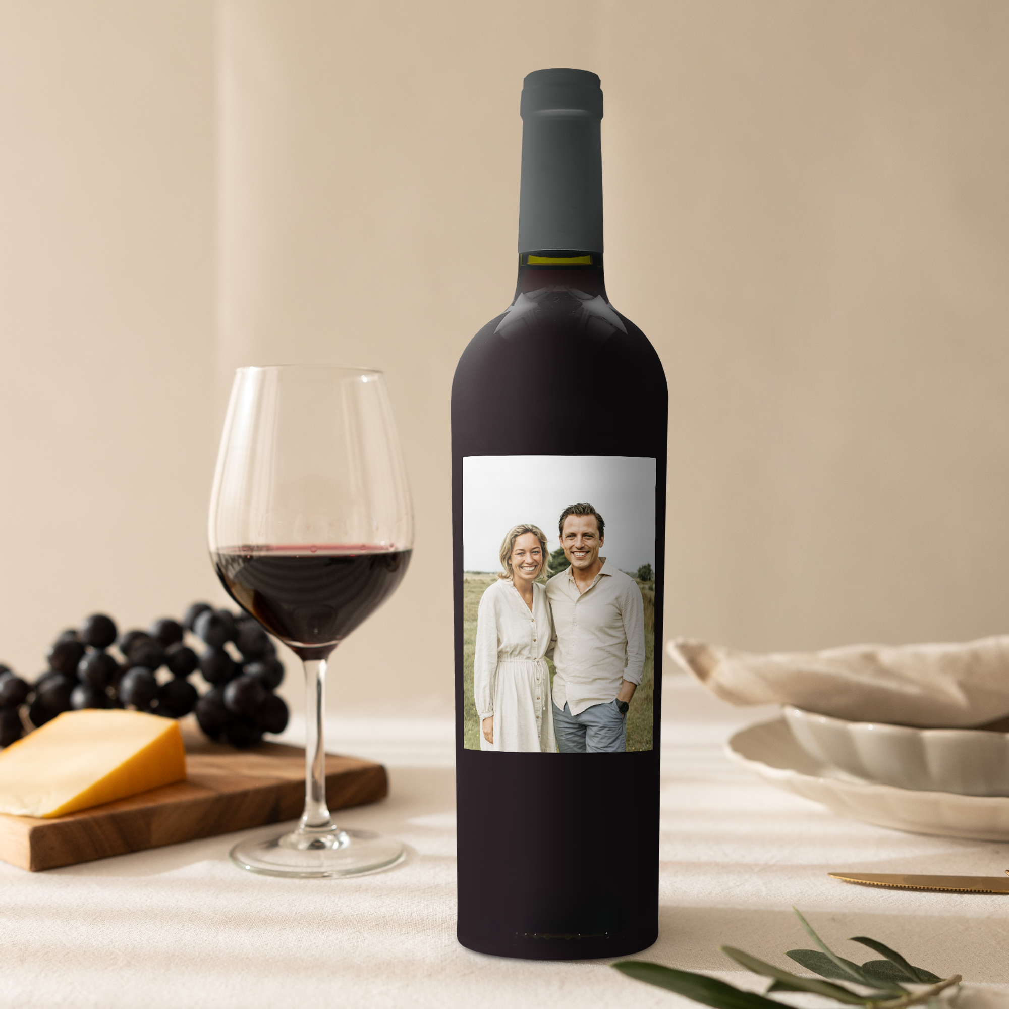 Láhev vína Riondo Merlot s navrženou etiketou s fotografií páru, sklenicí vína a sýrem