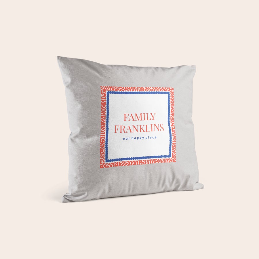 Personalizované potlačené vankúše Biely vankúšik s potlačou mena Family Franklins a textu our happy place, s červeným a modrým ornamentom.