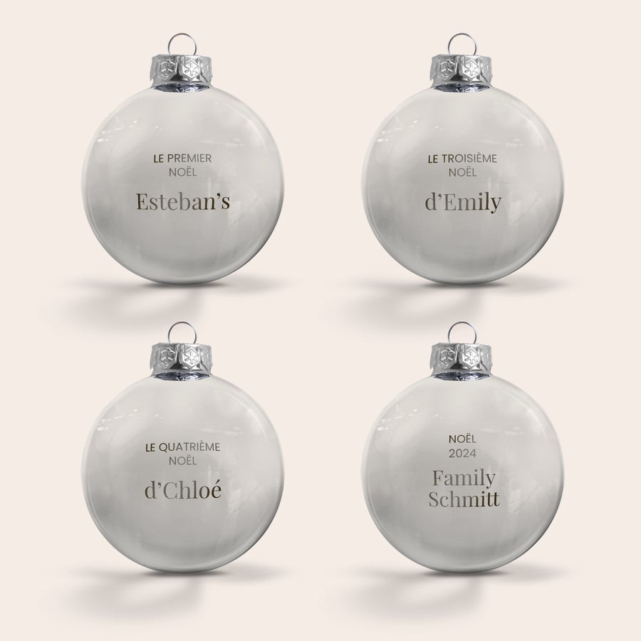 Boule de Noël Personnalisée en Verre Quatre boules de Noël en verre personnalisées et gravées avec un nom et un message pour décorer votre sapin.