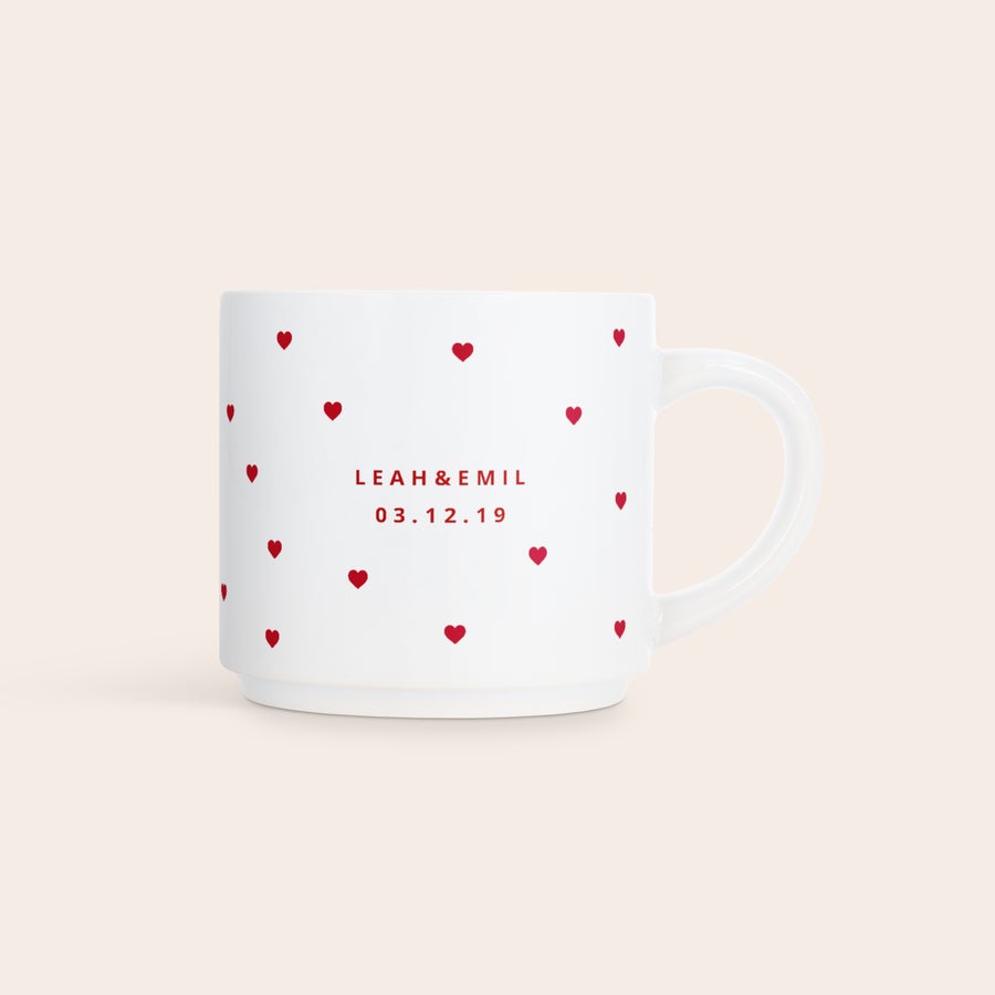 Stabelbare krus med bilde Hvit stablebar fotokrus med et rødt hjerte-mønster og teksten LEAH & EMIL 03.12.19, personliggjort med trykk.