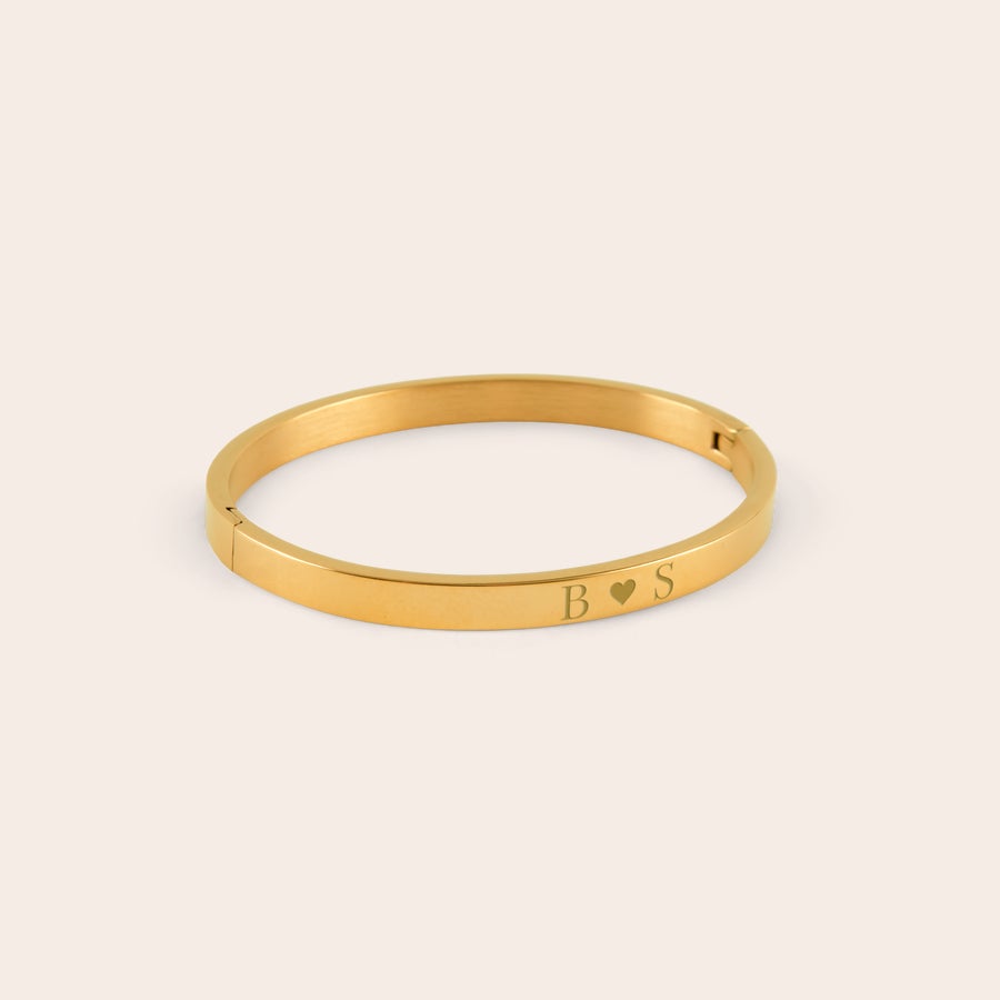 Personlig armband Guldfärgad personlig armring med graverade initialer B och S med ett hjärta emellan