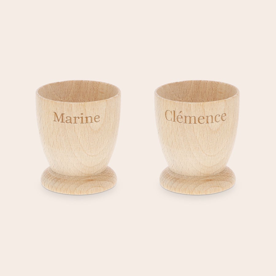 Coquetier personnalisé Deux coquetiers personnalisés en bois de hêtre avec les prénoms Marine et Clémence gravés, pour un petit-déjeuner inoubliable