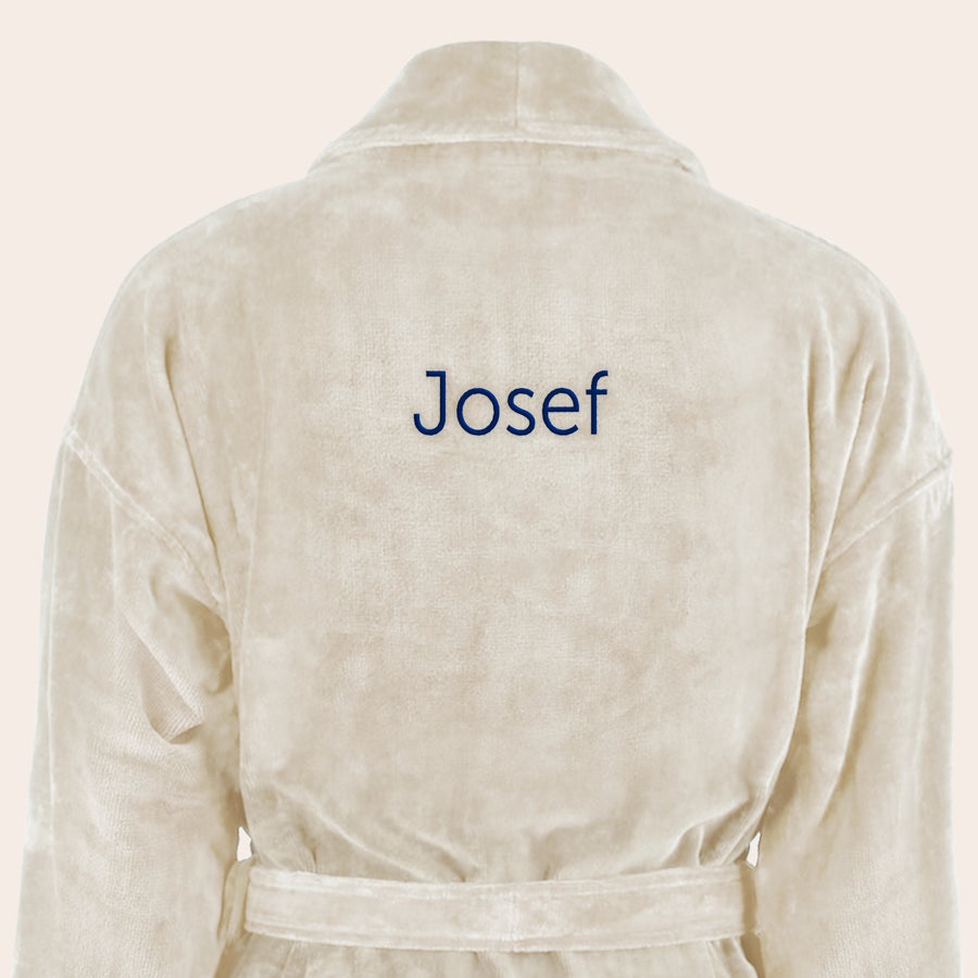 Badrock Herr med namn Mjuk beige badrock broderad med namnet Josef i blå text, perfekt att ge som gåva.