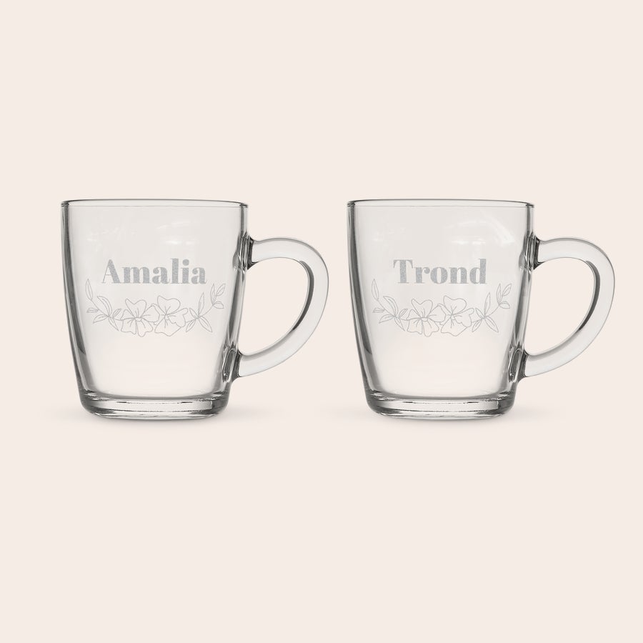 Tekopp med gravering To klare tekopper med gravering: en med Amalia og blomstermotiv, en med Trond og blomstermotiv.