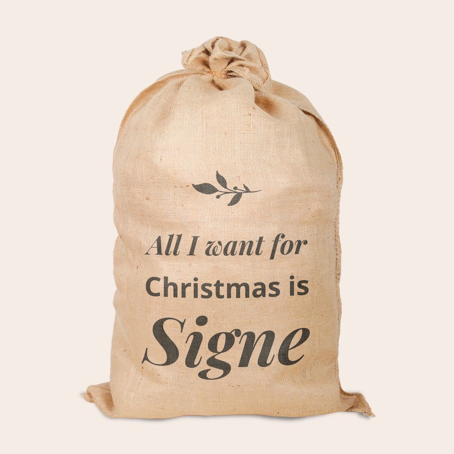 Personlig jute jul säck Jutsjulsäck i naturlig färg tryckt med designen All I want for Christmas is Signe och en kvist.