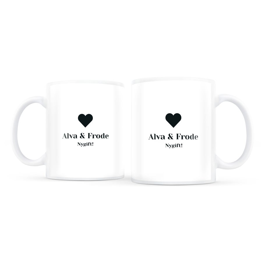 Krussett med foto To hvite personaliserte kjærlighetskrus, trykt med navnene Alva & Frode og teksten Nygift! under et svart hjerte.