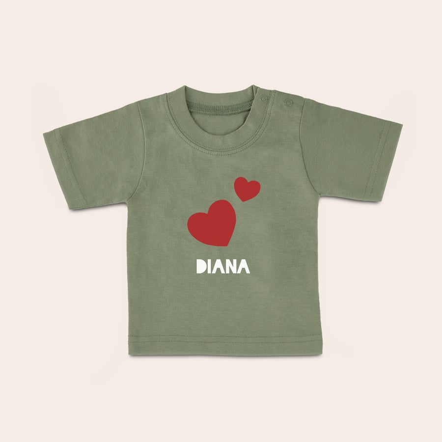 Baby t shirt bedrucken Grünes Baby T-Shirt mit zwei roten Herzen und dem Namen Diana, mit Wunschmotiv bedruckt.
