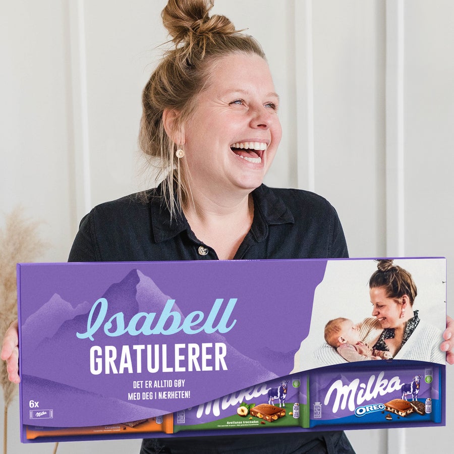 Giant personlig Milka-sjokolade En glad kvinne holder en XXL personlig Milka sjokoladeplate - 6 barer med navn, hilsen og eget bilde.