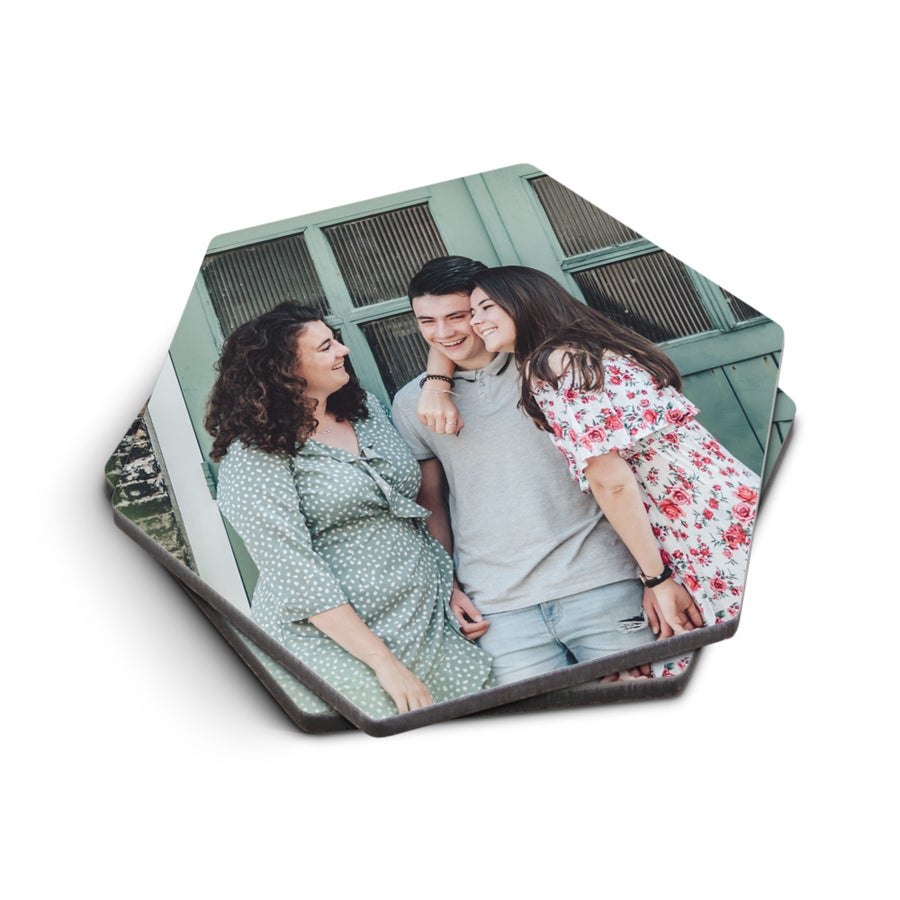Posavasos personalizados hexagonales impresos con una foto de tres amigos sonriendo.