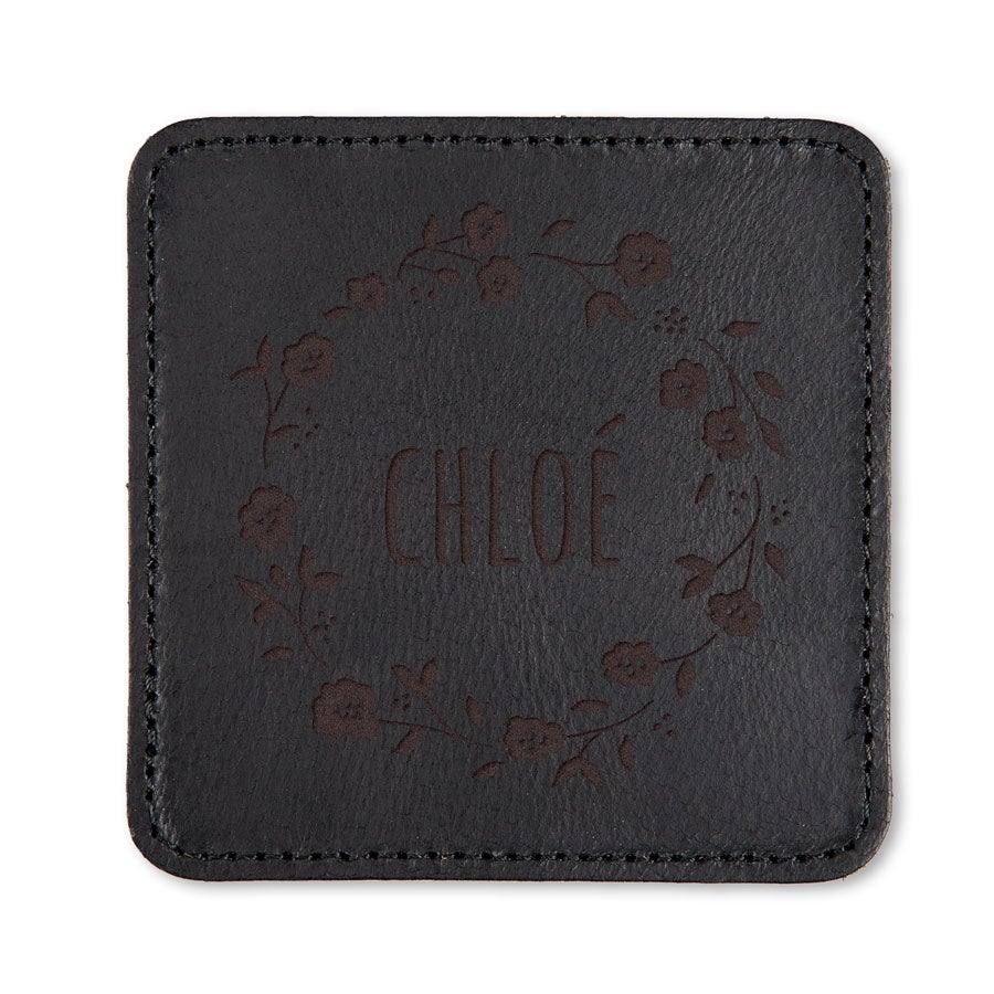 Sous-verre en cuir noir gravé avec le prénom CHLOÉ entouré d'une couronne de fleurs pour une surface parfaite