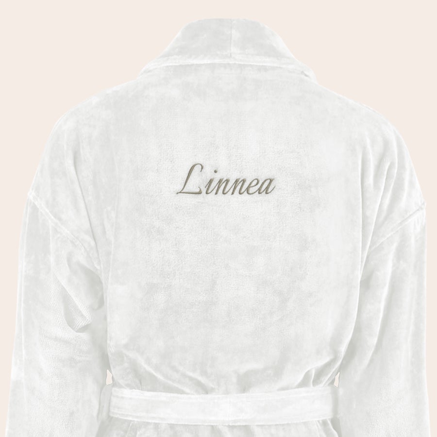 Badrock Dam med namn Vit mjuk badrock i bomull med namnet "Linnea" broderat i brunt på ryggen, en personlig gåva.