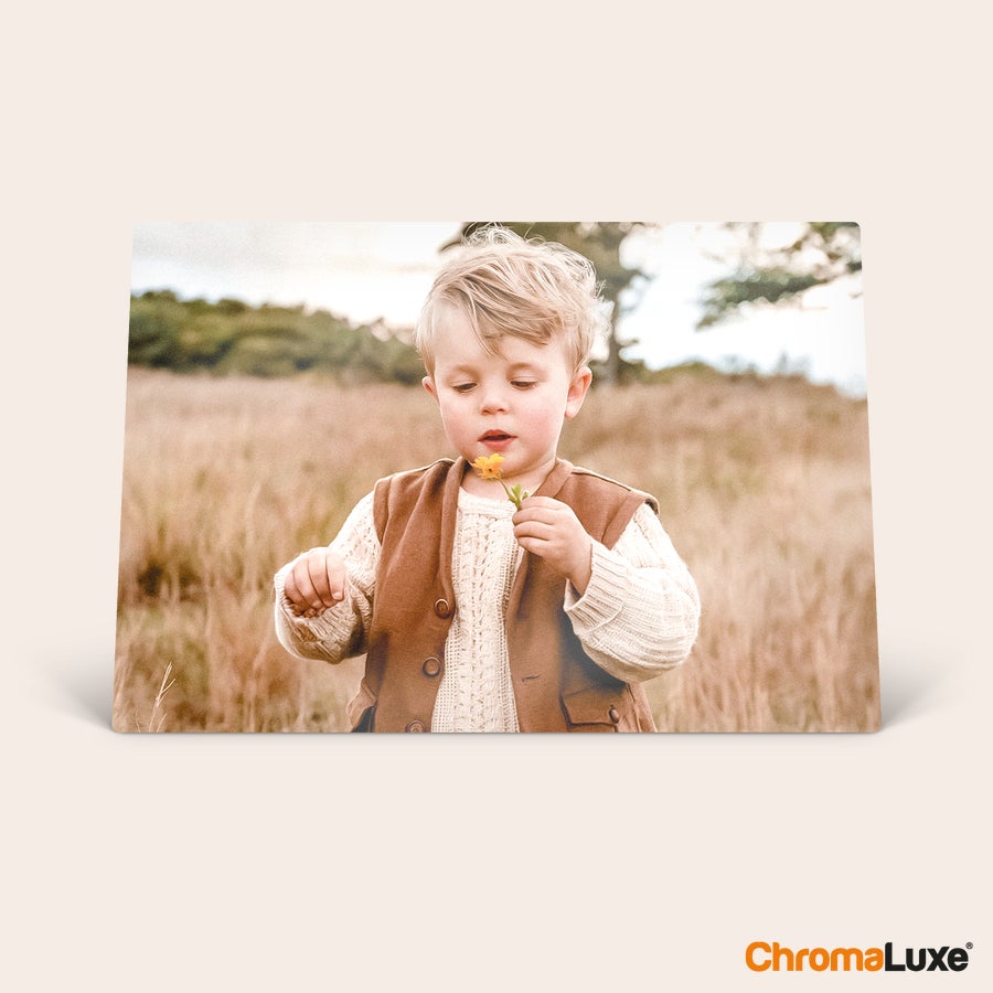 Cadre photo aluminium Cadre photo personnalisé ChromaLuxe avec impression d'un enfant aux cheveux blonds tenant une fleur jaune.