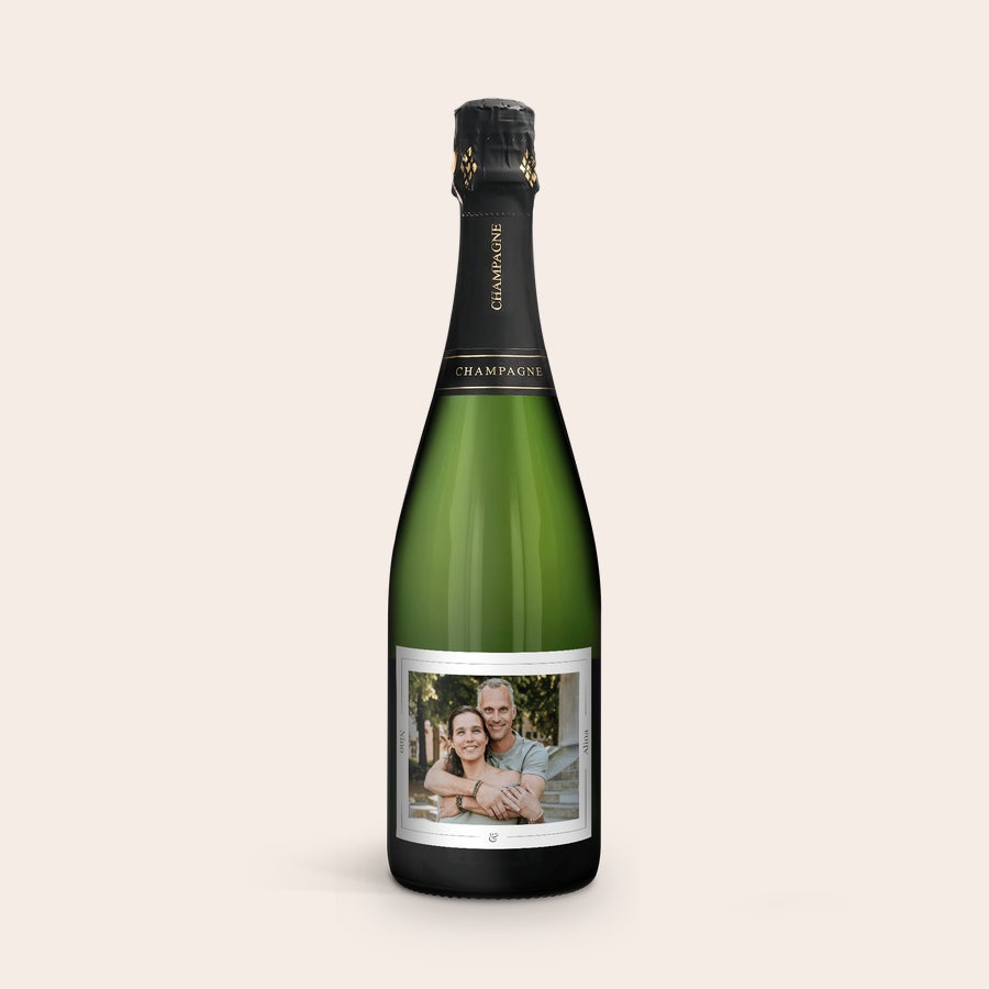 Champagner Rene Schloesser (750ml) personalisieren Grüne Champagnerflasche mit individuellem Etikett. Das personalisierte Etikett zeigt ein Paarfoto und die Namen Nina & Alroa.