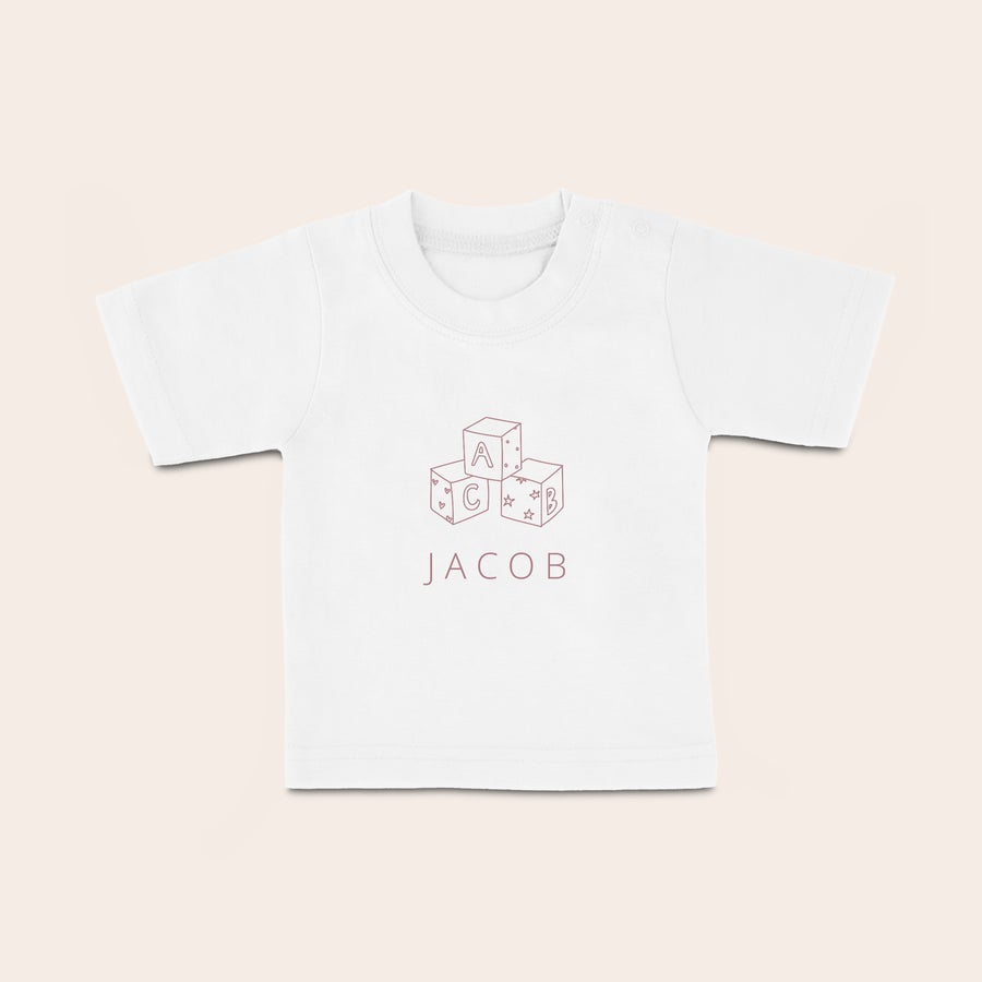 Poosebljena majica - Baby Bela otroška majica z natisnjenimi rdečimi kockami ABC in imenom Jacob. Vaš malček bo v svoji lastni osebni otroški majici zelo eleganten!