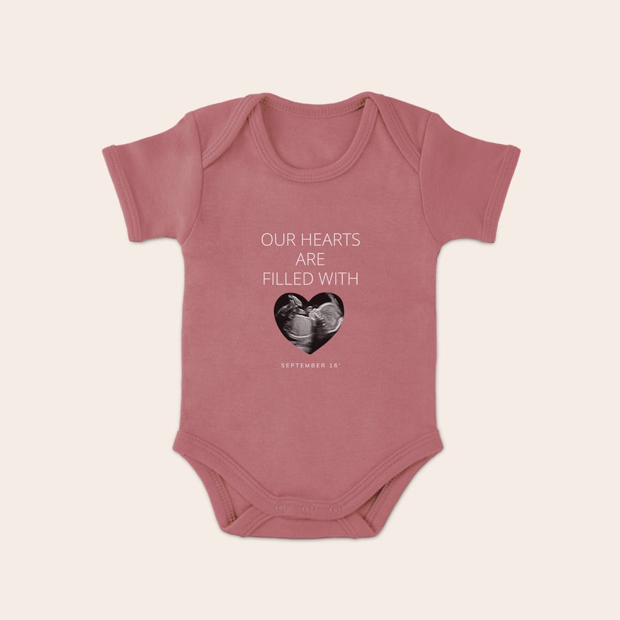 Body med eget tryck Rosa babybody med eget tryck av ultraljudsbild, texten "OUR HEARTS ARE FILLED WITH" och datumet "SEPTEMBER 16"