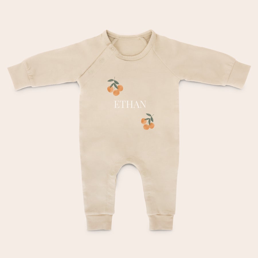 Costum de joacă pentru bebeluși Costum personalizat bej din bumbac moale, imprimat cu numele Ethan și două ilustrații cu portocale.
