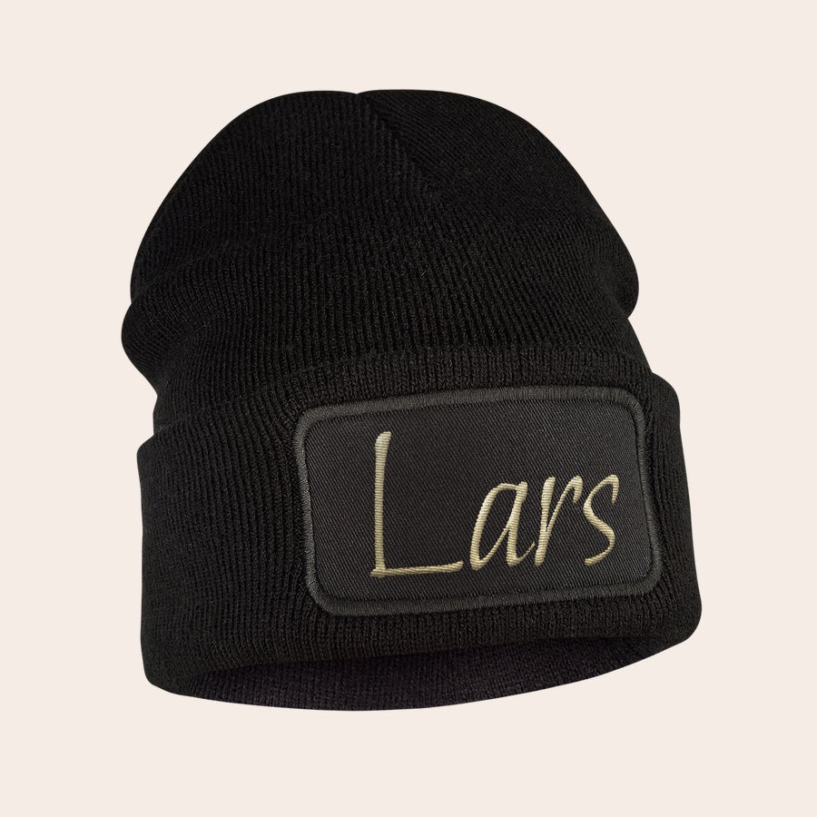 Hue med navn - Broderet Sort beanie med et broderet navn, "Lars", i guldskrift på et sort mærke. Hold ørerne varme med en cool beanie.