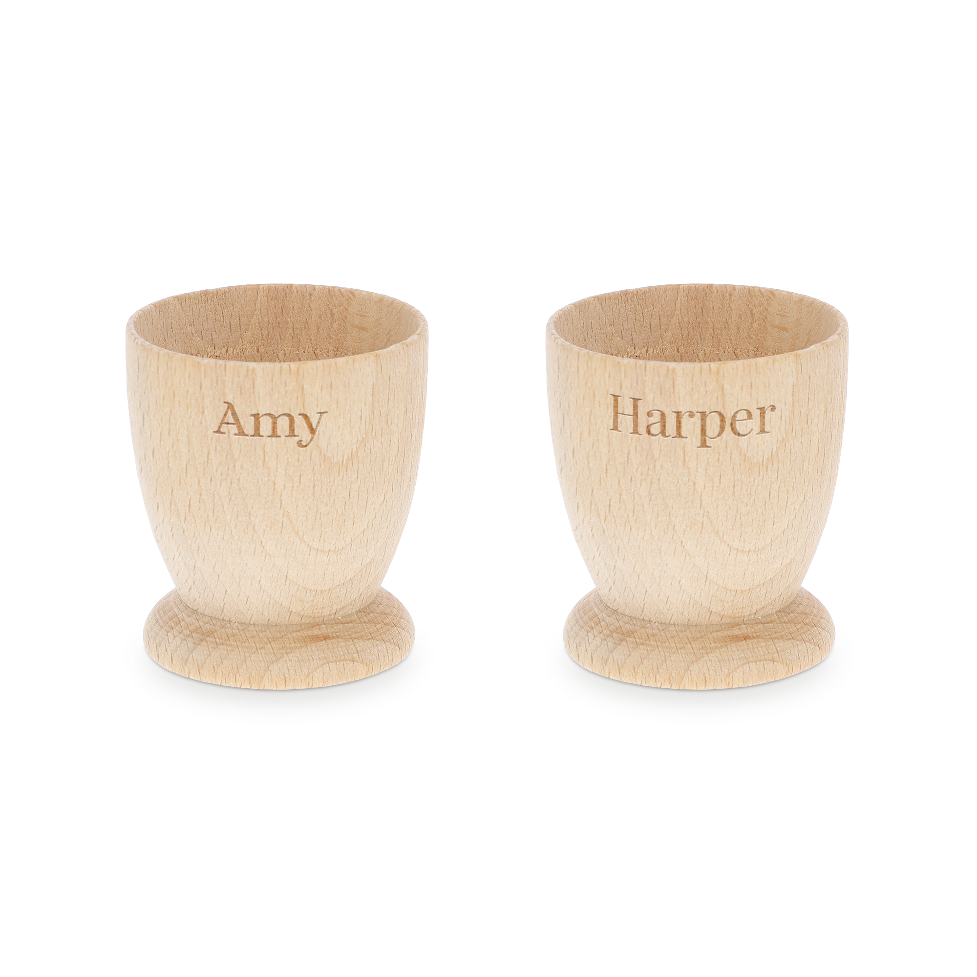 Două cupe pentru ouă din lemn de fag, personalizate prin gravură cu numele Amy și Harper, pentru un mic dejun memorabil.