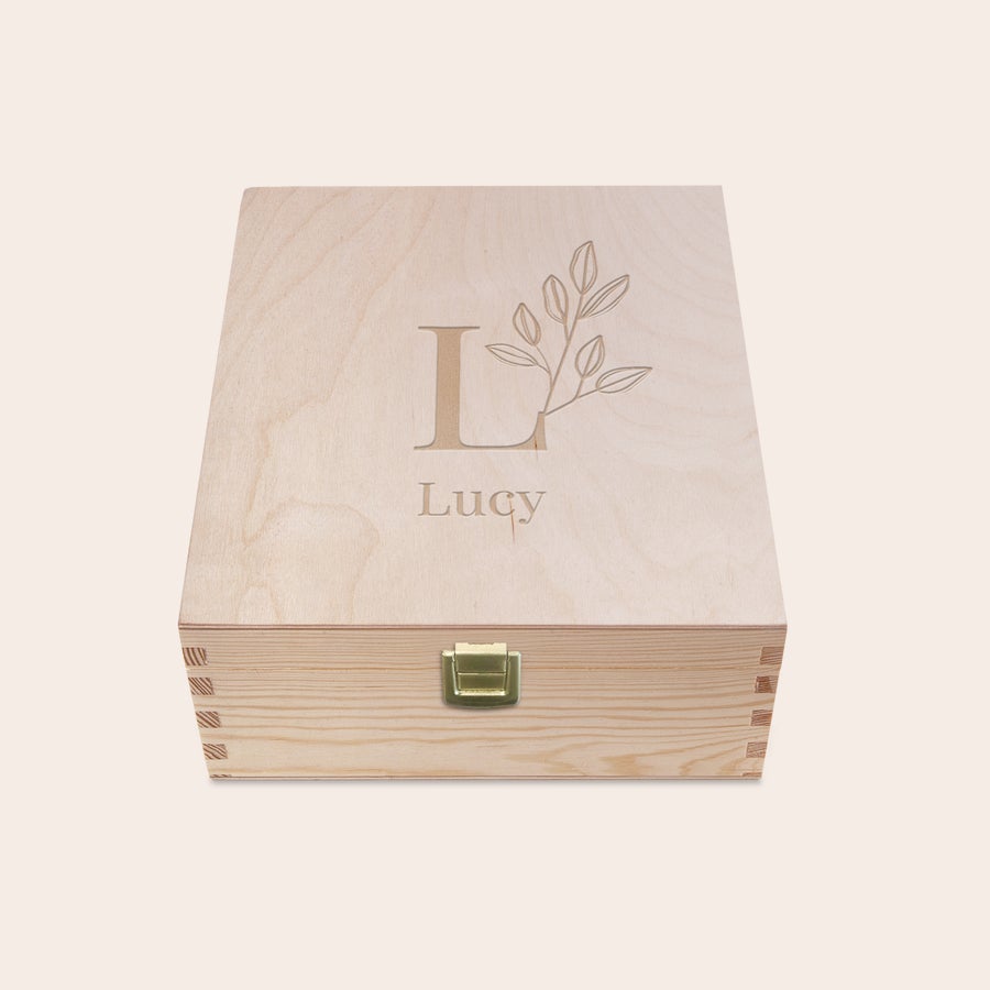 Fa gravírozott teásdoboz Világos fa teásdoboz Lucy névvel és L betűvel gravírozva, mellette levélminta a fedélen.