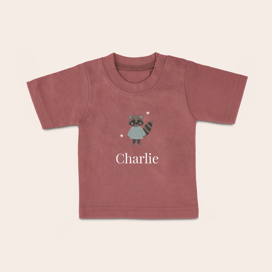 Baby T-shirt Babyskjorta i korallrosa med tryckt motiv av en tvättbjörn och texten Charlie, perfekt för ditt lilla barn