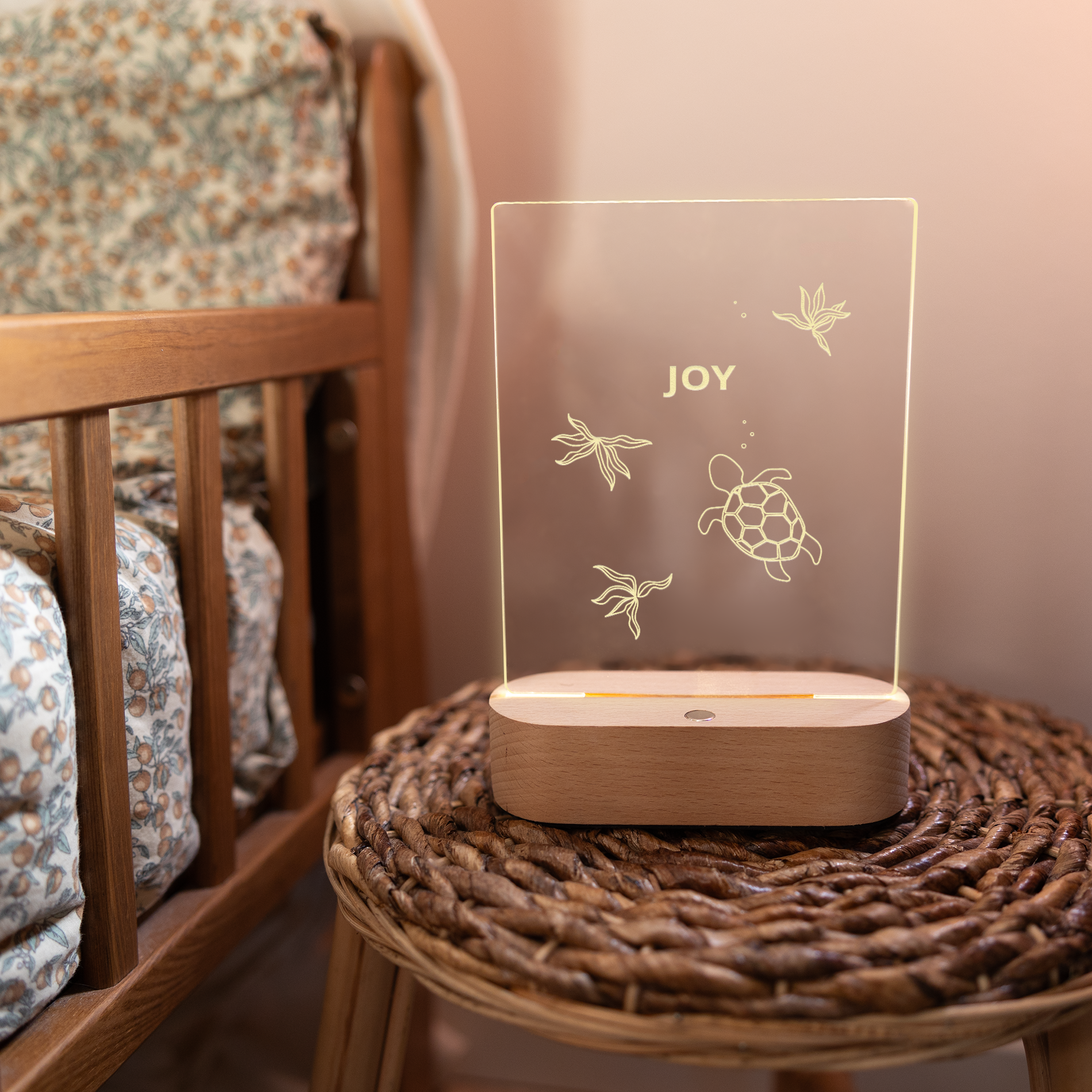 Gegraveerde lamp met een schildpad en zeewier, gegraveerd met de naam 'JOY' op een houten voet