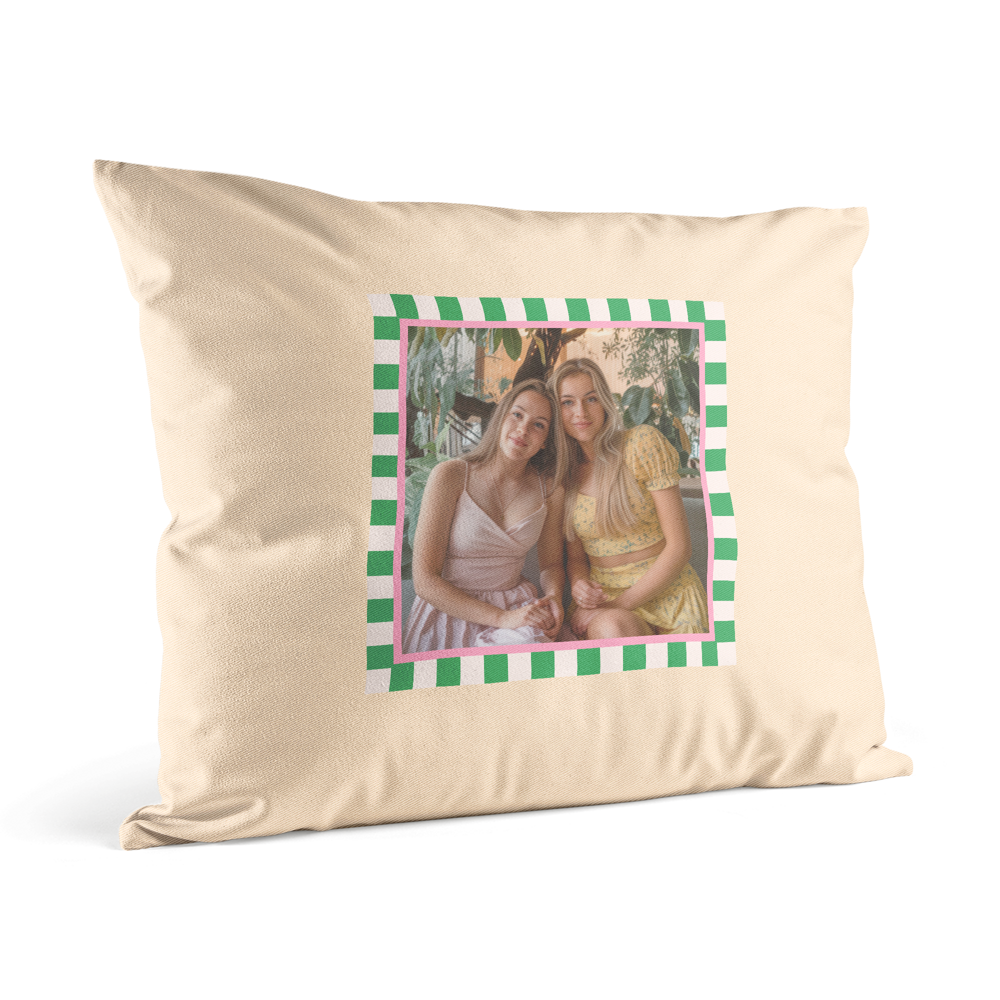 Ljusbeige personligt kuddfodral med ett tryckt foto av två leende tjejer omgivet av en grönvit randig och rosa kant för att förvandla vilket utrymme som helst.