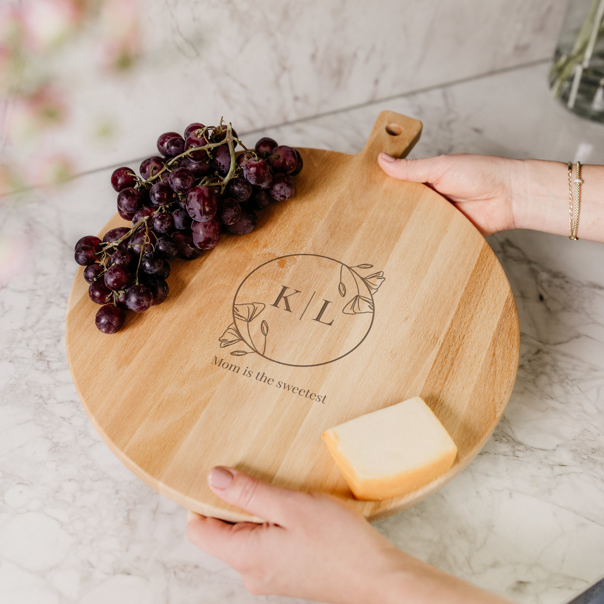 Personal wooden serving platter with name and message engraved, holding grapes and cheese