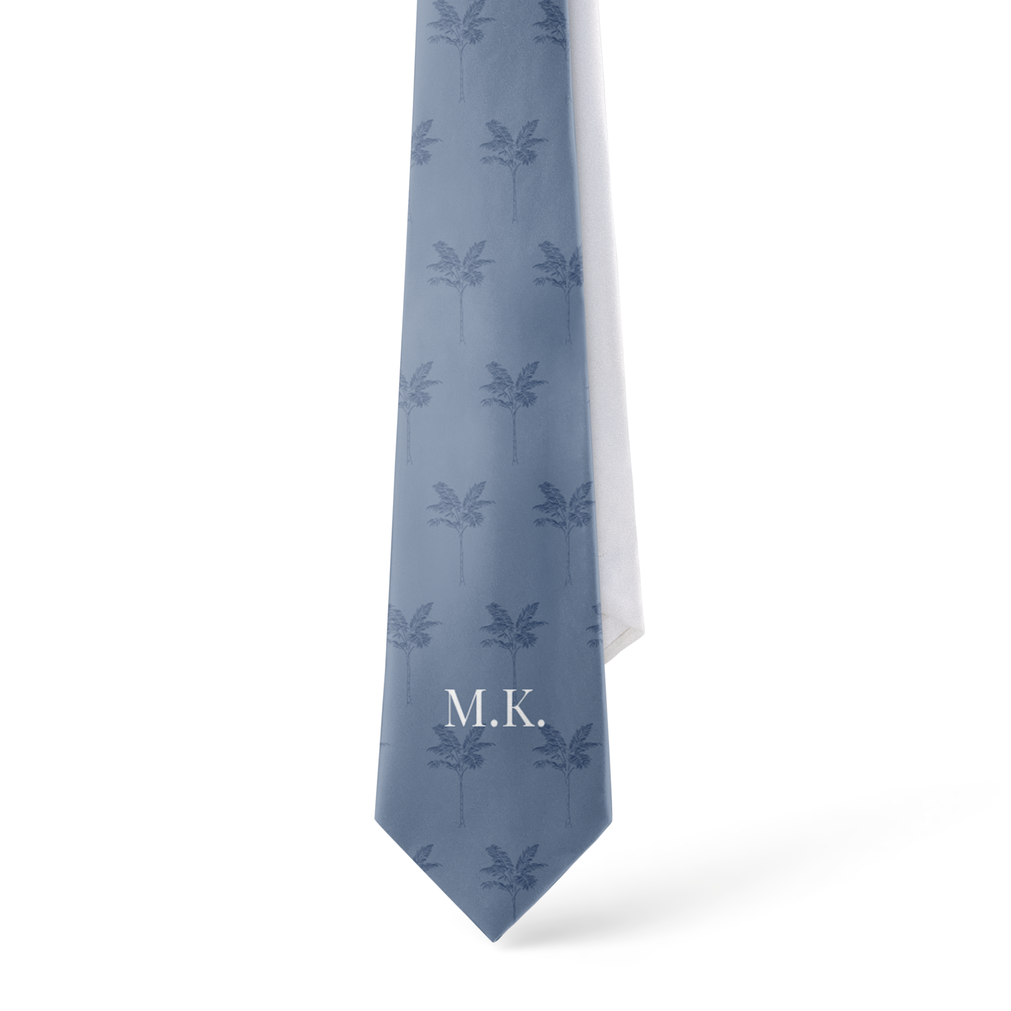 A personalised tie in light blue with a palm tree pattern and M.K. printed in white