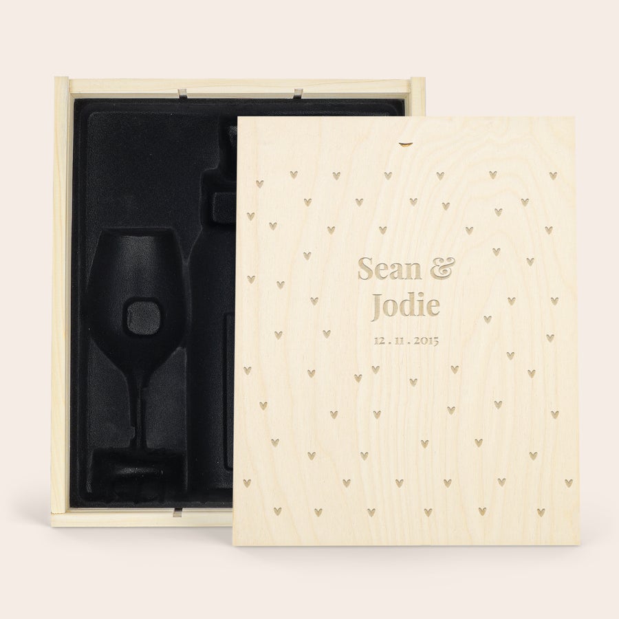 Személyre szabott fa tok Egy deluxe fa táska személyre szabott gravírozással, szív mintával, "Sean & Jodie 12.11.2015" szöveggel, egy üveg és 2 borospohár számára kialakított bársony belsővel.
