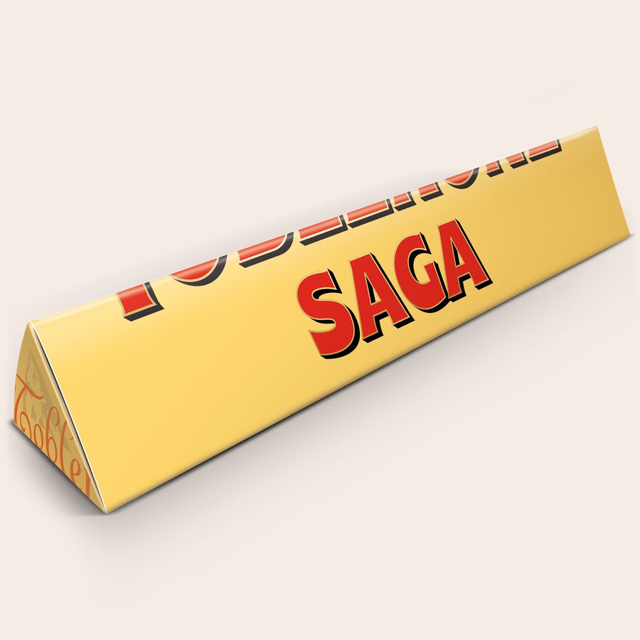 Toblerone XXL med navn Personliggjort Toblerone XXL med navnet Saga trykt på den gule indpakning. Denne personliggjorte Tobleronebar i størrelse XXL er i bogstavlig forstand en STOR overraskelse.