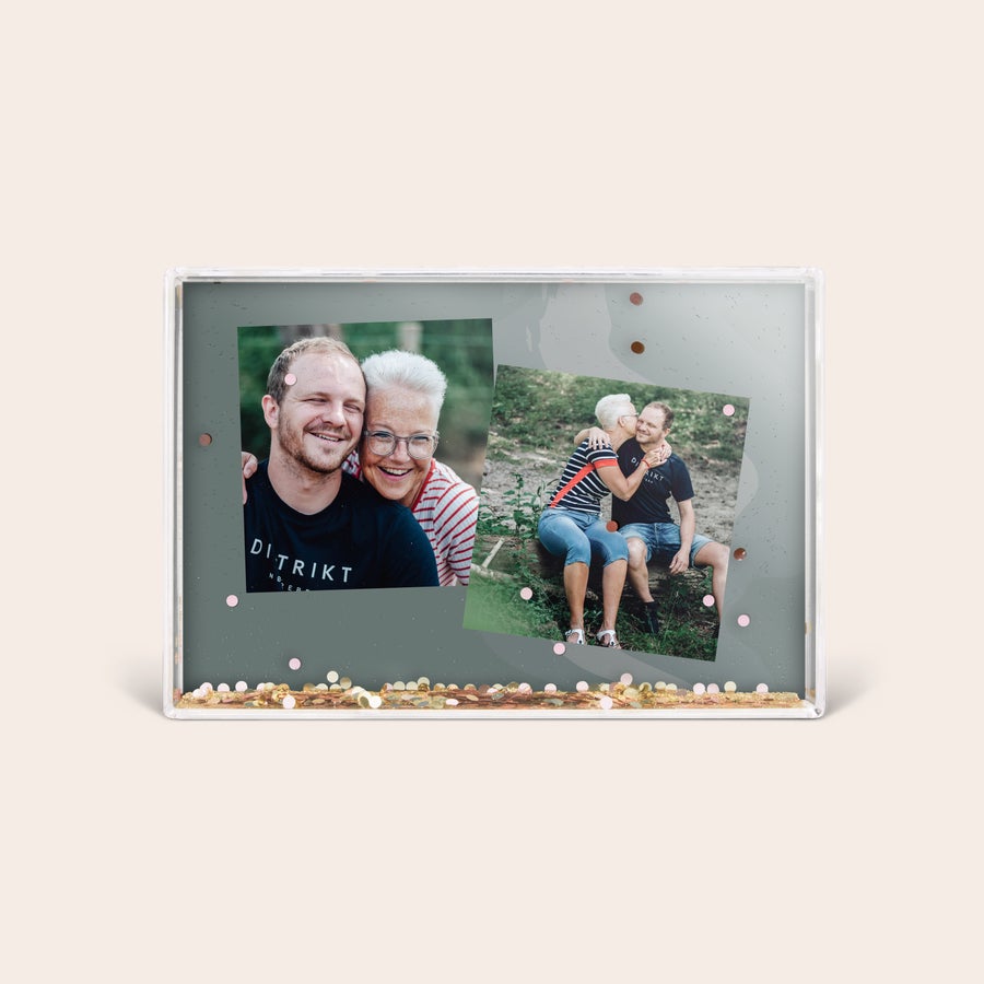 Snøblokk med foto En personlig hjerteblokk med glitter og to bilder av et eldre kvinne og en yngre mann i forskjellige poseringer.