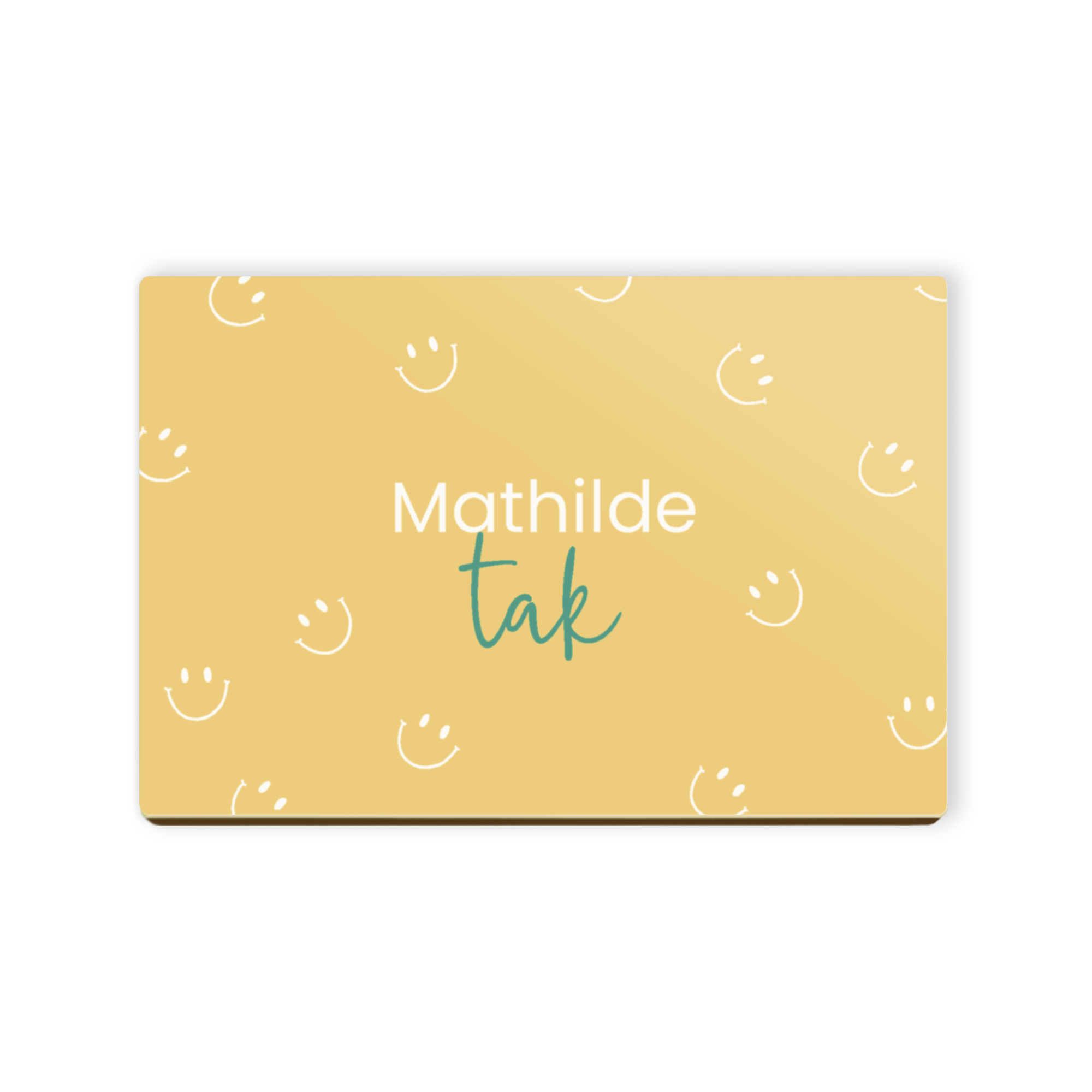 Personligt chokoladebrev i mælkechokolade med navn "Mathilde" og ordet "tak" trykt i hvidt på en gul baggrund med smilies.