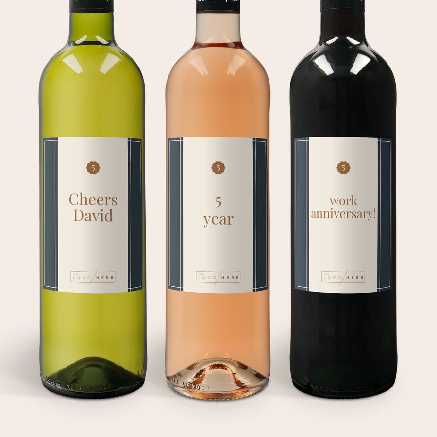 Set de regalo de vino Maison de la Surprise Caja de regalo de vino Luc Pirlet con botella de vino blanco, rosado y tinto, con etiquetas personalizadas con texto y logo.