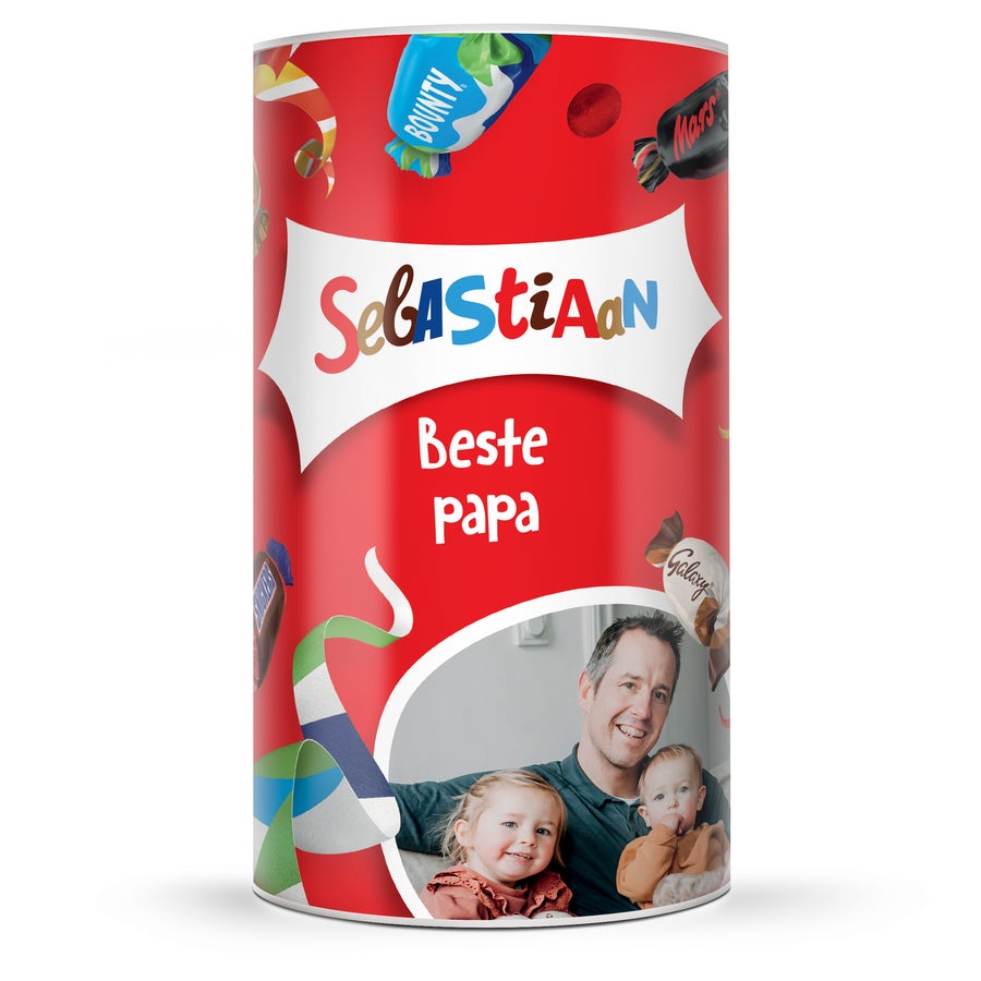 Celebrations XL chocolade cadeauverpakking met naam en foto Rode Celebrations tube bedrukt met naam Sebastiaan, tekst Beste papa en een foto van een vader met twee kinderen
