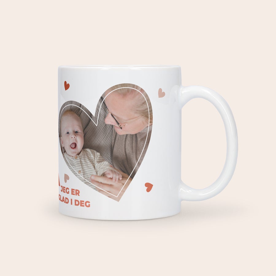Morsdag kopp med bilde Hvit morsdagens kopp med bilde av baby og bestemor trykt i et hjerte, med teksten Jeg er glad i deg.
