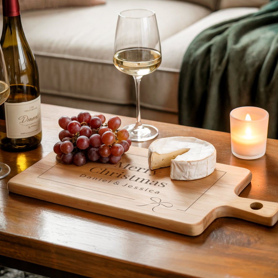 Personalised wooden serving platter Personalised serving platter - Beech - Rectangular - Landscape - M - Engraved with "Merry Christmas Daniel & Jessica" and a bow design, holding grapes and cheese.
