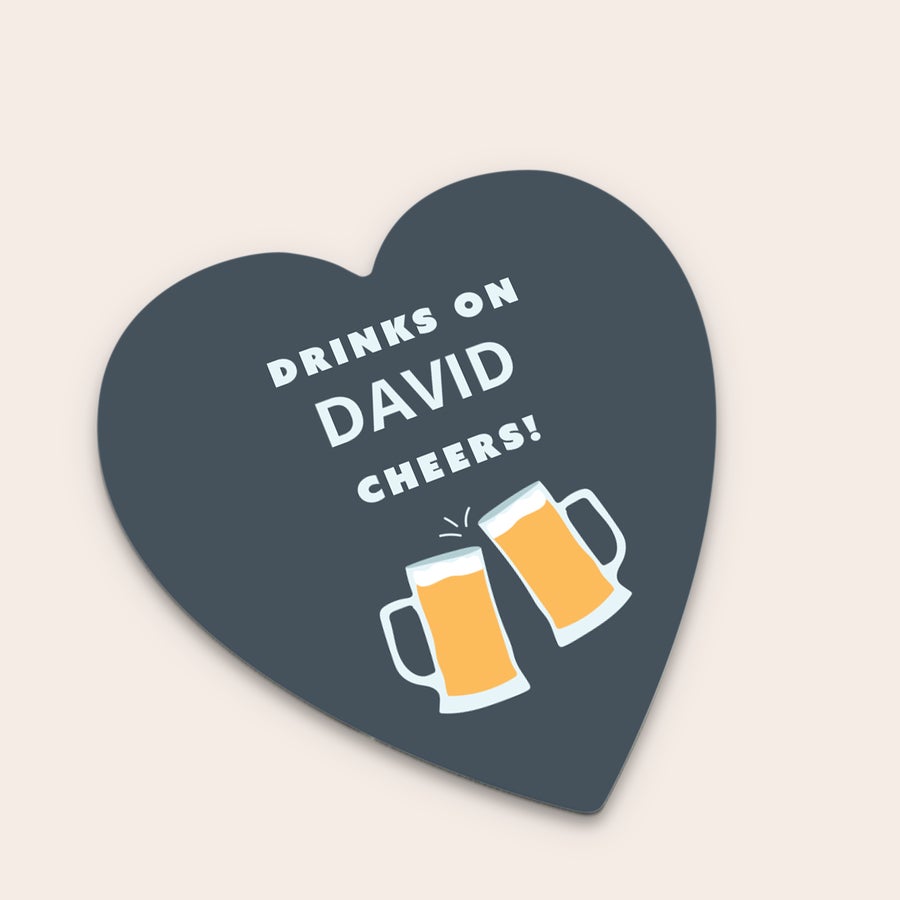 Pivné tácky Sivá personalizovaná podložka pod pohár v tvare srdca s potlačou "DRINKS ON DAVID CHEERS!" a dvoma pollitrami piva