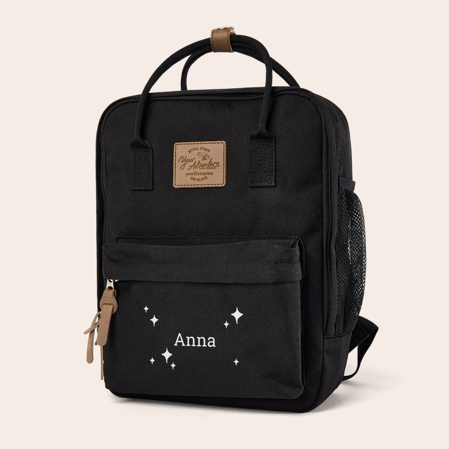 Lasten reppu nimellä Musta lasten reppu, etutaskussa valkoisella painettu nimi Anna ja tähtiä. Luo lapselle upea, yksilöity reppu omalla nimellä.