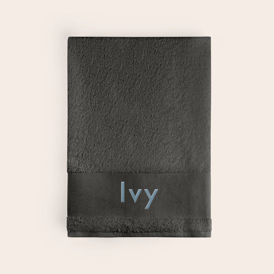 Toalha de banho com texto Toalha de banho antracite com nome Ivy bordado a azul, cria algo único com uma toalha de banho antracite personalizada