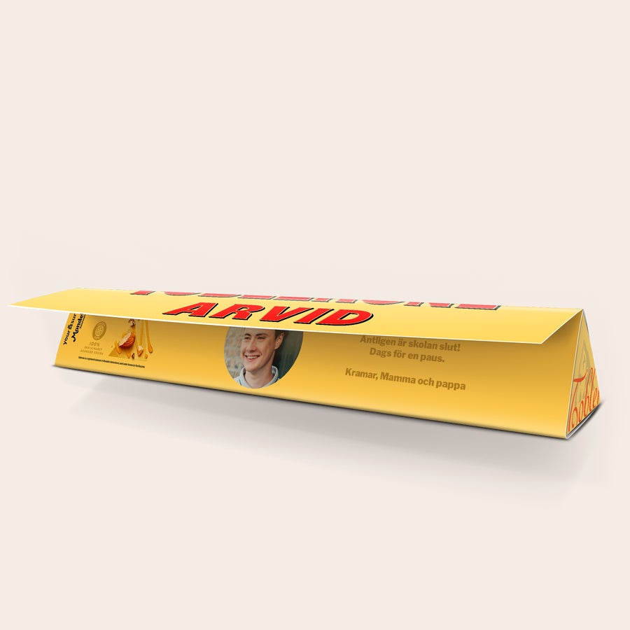 Toblerone med namn Personaliserad Toblerone med foto och texten "Äntligen är skolan slut! Dags för en paus. Kramar, Mamma och pappa" tryckt i fullfärg.