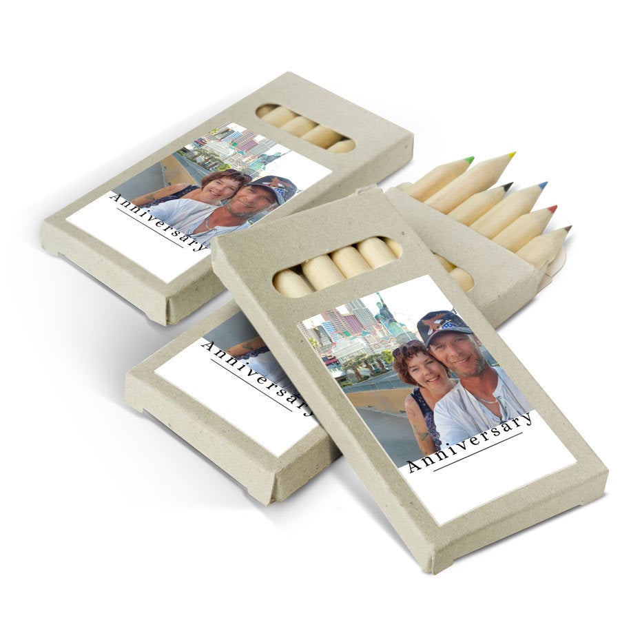 Caixas com lápis de cor personalizados para os convidados, impressas com foto e texto "Anniversary"