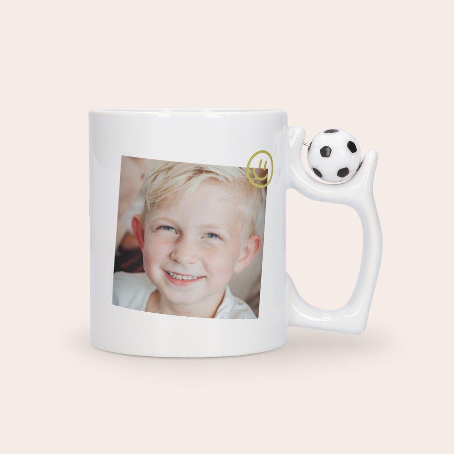 Fotomugg - Fotboll Vit keramikmugg med fotboll på örat tryckt med ett personligt foto och text på en glad pojke, en fin mugg i present