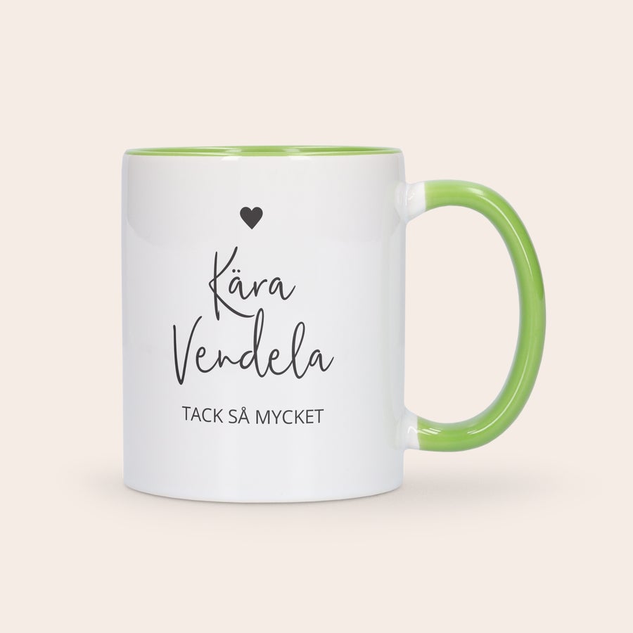 Färgade muggar Vit och grön färgglad mugg med personlig text Kära Vendela Tack så mycket tryckt på framsidan, med ett hjärta ovanför namnet.